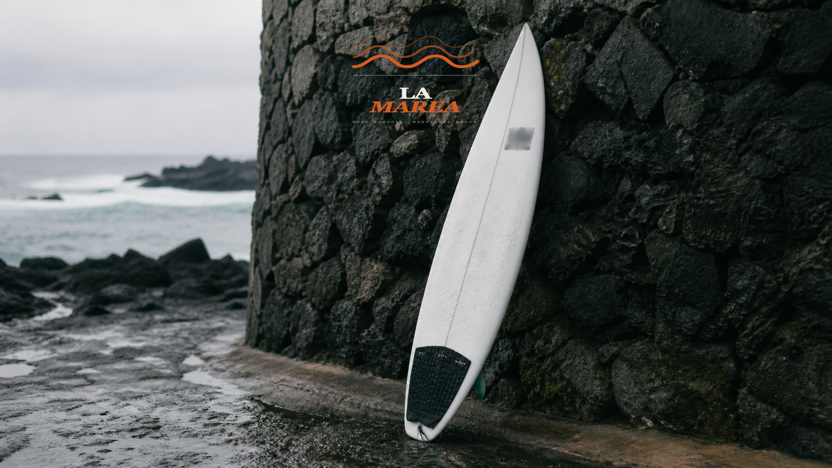 La Marea board nose decal against volcanic stone wall